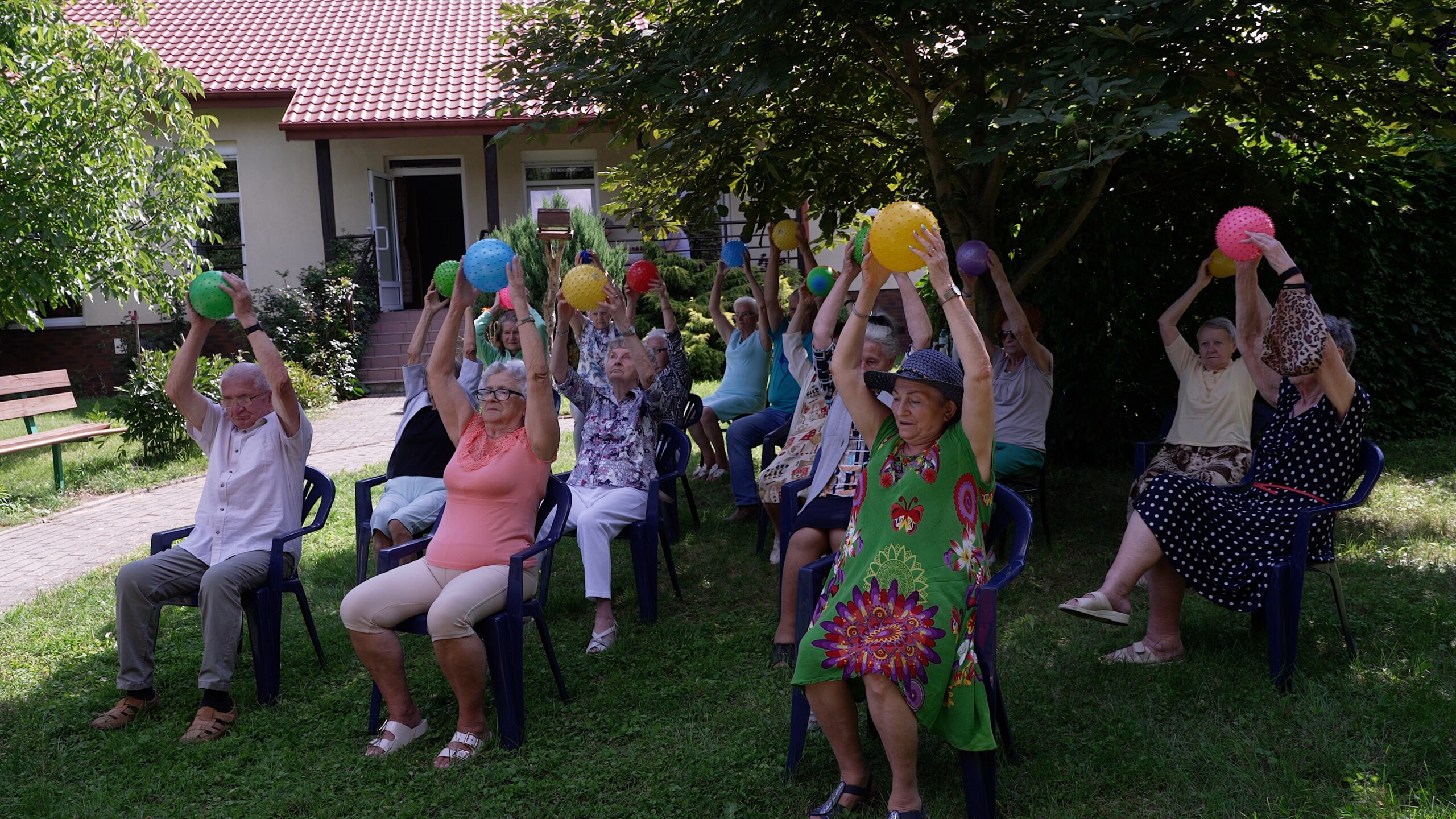Seniorzy ćwiczą podczas zajęć na świeżym powietrzu